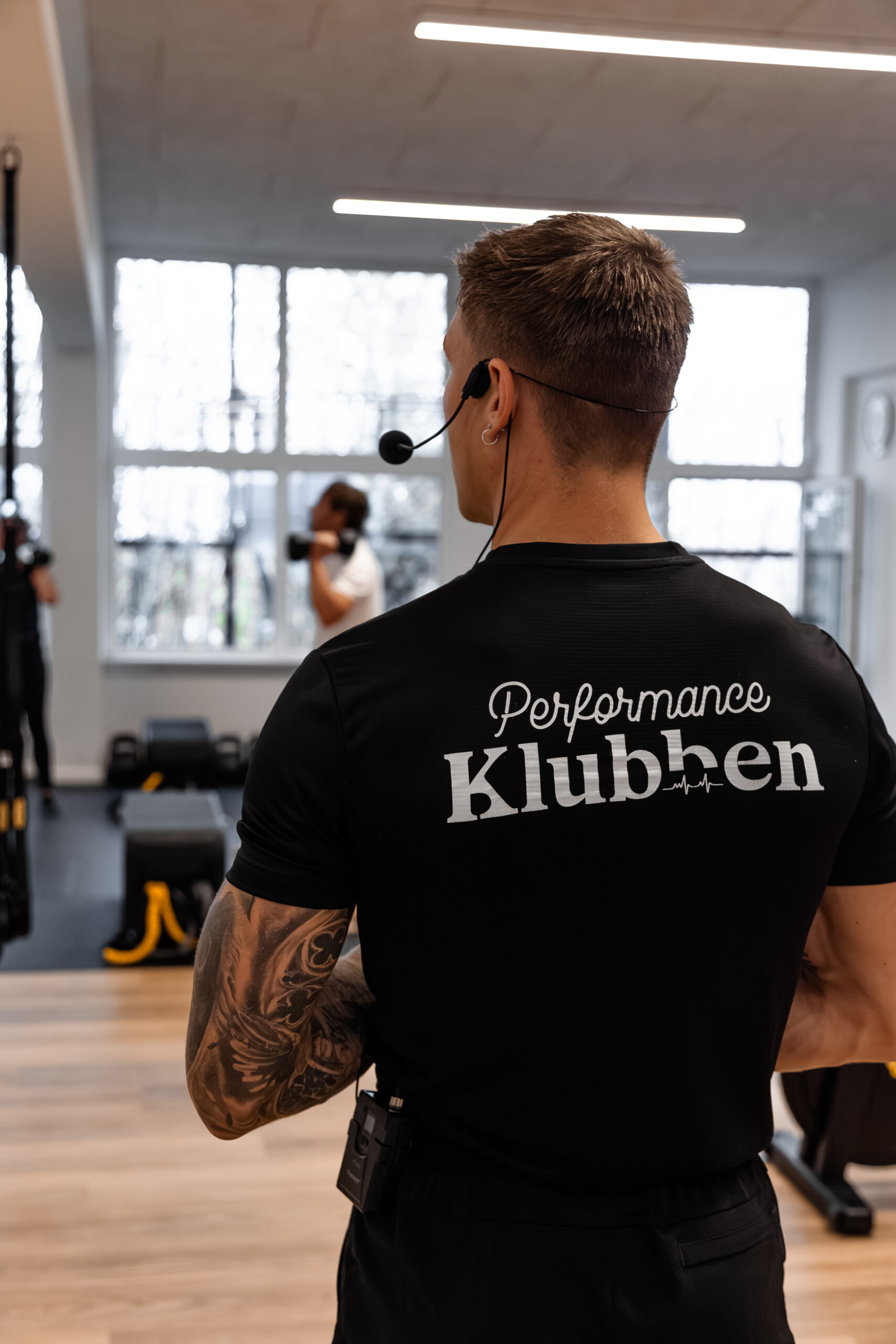 Instruktør med headset i Performance Klubben Højbjerg til guidet holdtræning og personlig træning i Aarhus.