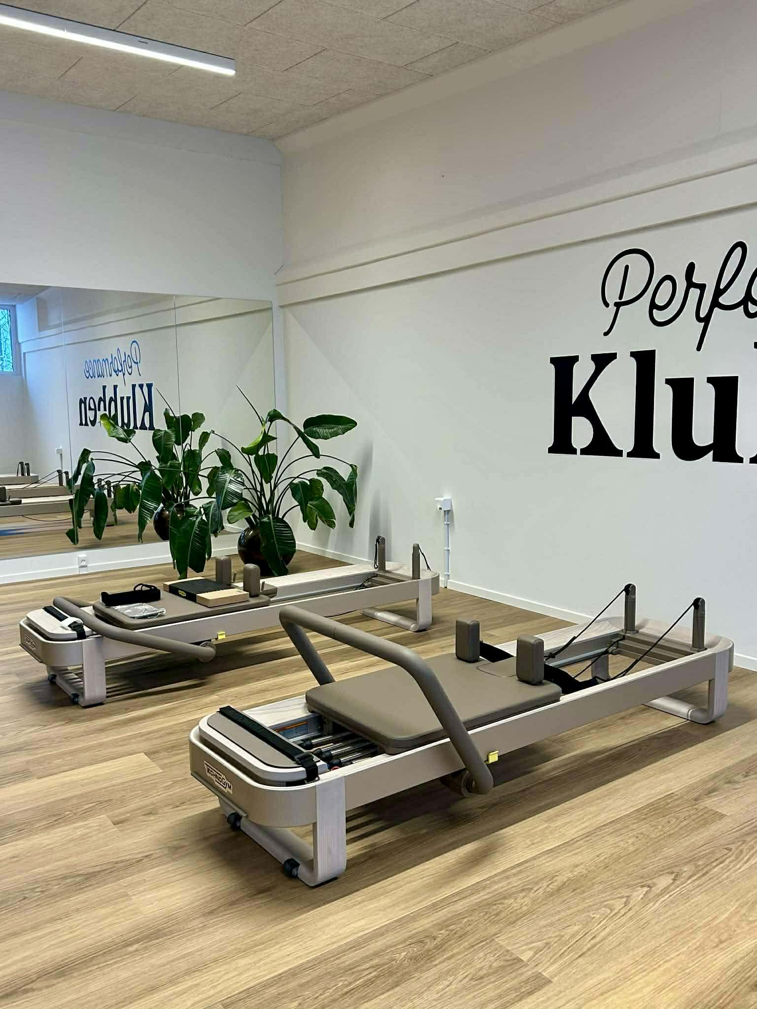 To moderne Technogym Reformer-maskiner i et lyst træningslokale hos Performance Klubben i Højbjerg, Aarhus.